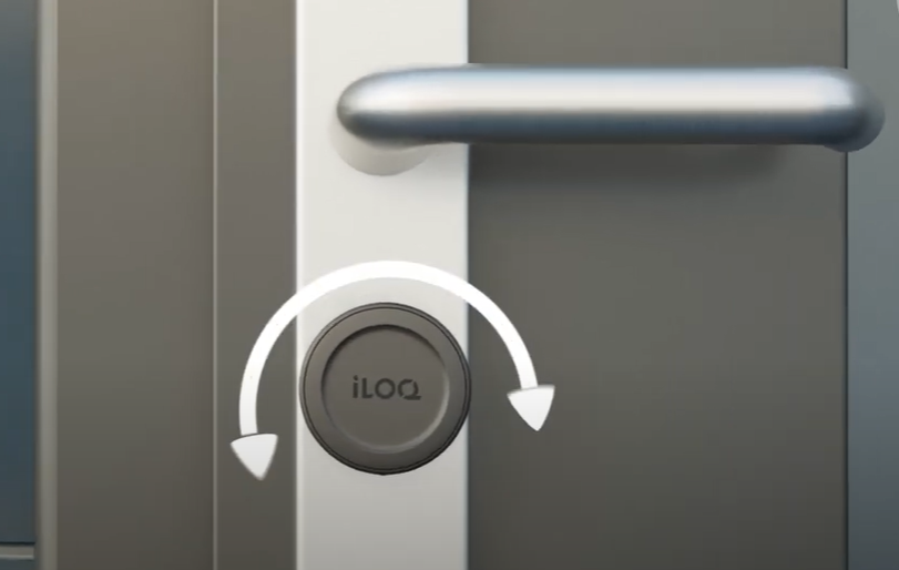 An iLOQ round door knob with arrows showing which way to turn